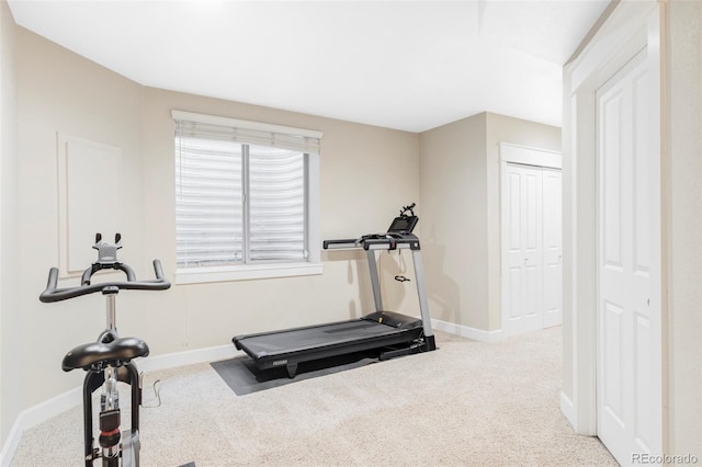 exercise room with baseboards and carpet