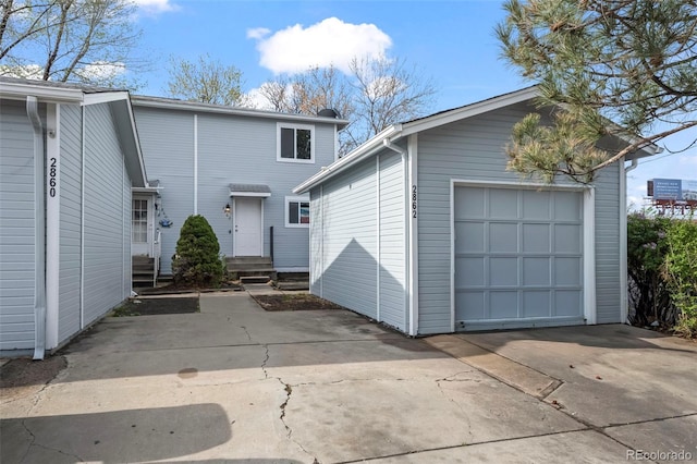 view of front of house featuring concrete driveway, an outdoor structure, and a detached garage