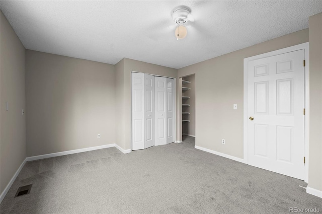 unfurnished bedroom featuring carpet floors, baseboards, visible vents, and a closet