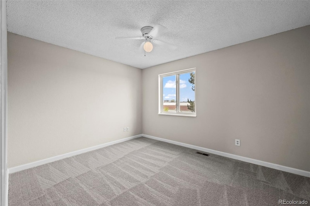 spare room with baseboards, ceiling fan, carpet floors, and visible vents