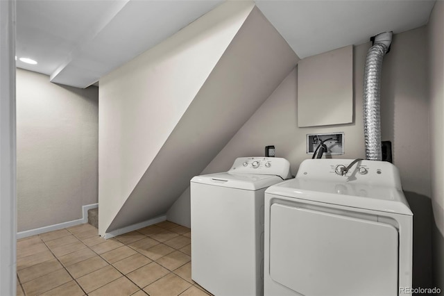 washroom with light tile patterned floors, baseboards, laundry area, and washing machine and dryer