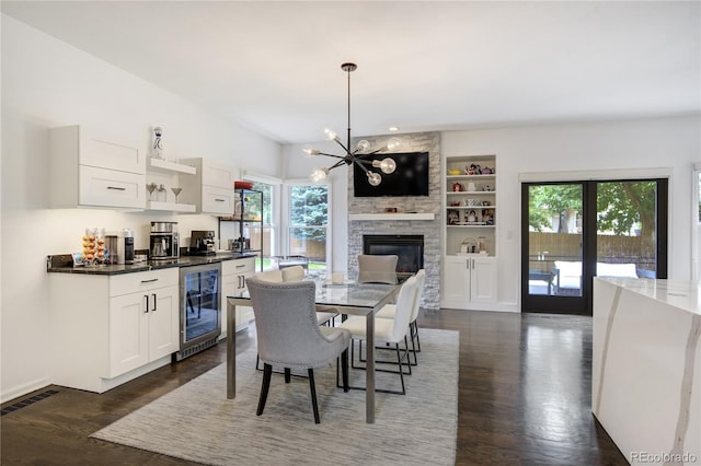 11389 E Maplewood Ave, Englewood, CO 80111 - dining space featuring wine cooler, dark wood-style floors, a chandelier, and built in shelves