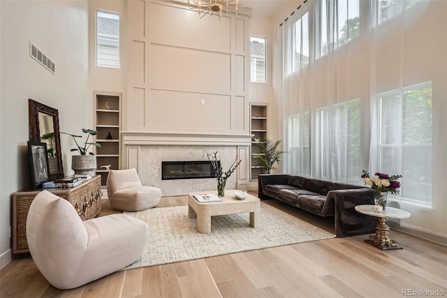22367 Quail Run Dr, Parker, CO 80138 - living area featuring a towering ceiling, plenty of natural light, a fireplace, and wood finished floors