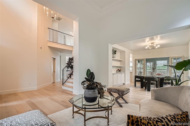 22367 Quail Run Dr, Parker, CO 80138 - living area featuring a chandelier, light wood-style floors, stairs, built in features, and a high ceiling