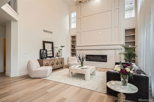 22367 Quail Run Dr, Parker, CO 80138 - living room featuring a towering ceiling, wood finished floors, built in features, and a tile fireplace