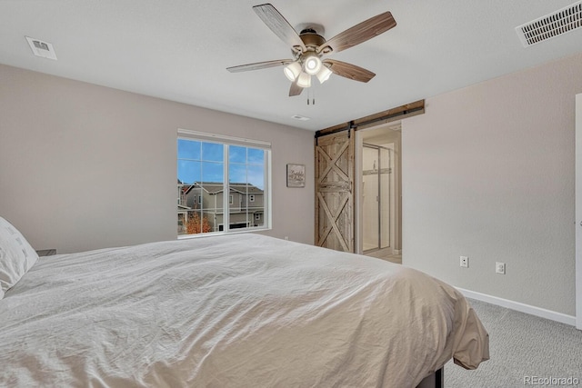 bedroom featuring a barn door, light colored carpet, and ceiling fan