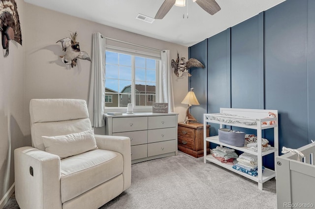 sitting room featuring light colored carpet and ceiling fan