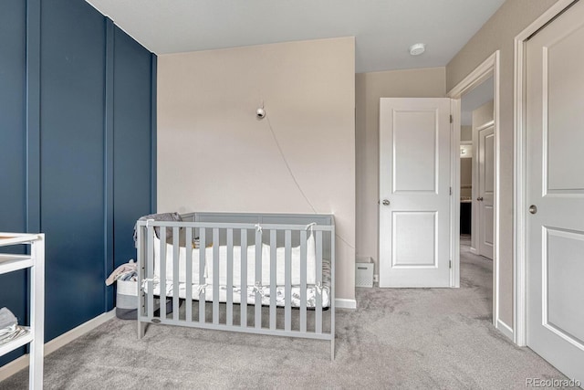 carpeted bedroom with a nursery area