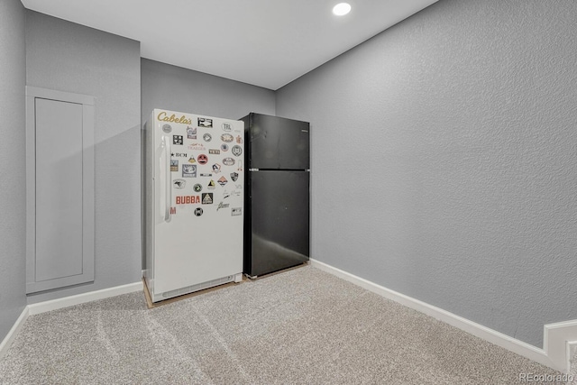 kitchen featuring carpet, white fridge, and black refrigerator