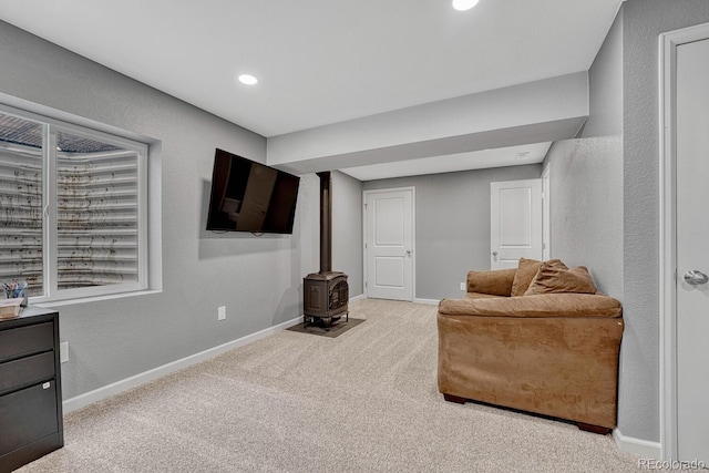 living area with light colored carpet and a wood stove