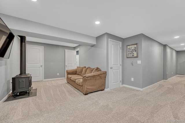 living room featuring a wood stove and light colored carpet