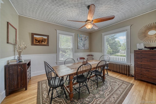 403 Scott St, Salida, CO 81201 - dining space featuring radiator, crown molding, wainscoting, light wood-style floors, and a ceiling fan