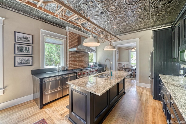 403 Scott St, Salida, CO 81201 - kitchen with a sink, wall chimney exhaust hood, an ornate ceiling, light wood-style floors, and stainless steel appliances