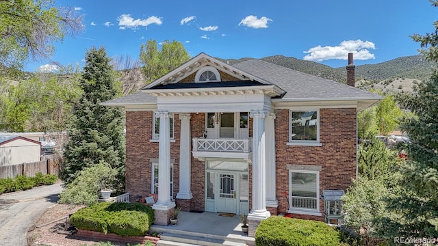 403 Scott St, Salida, CO 81201 - neoclassical home with brick siding, a mountain view, a chimney, and a shingled roof