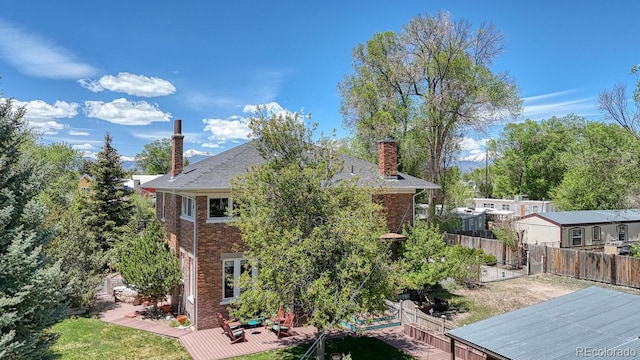 403 Scott St, Salida, CO 81201 - rear view of house featuring a chimney, a fenced backyard, a deck, and brick siding
