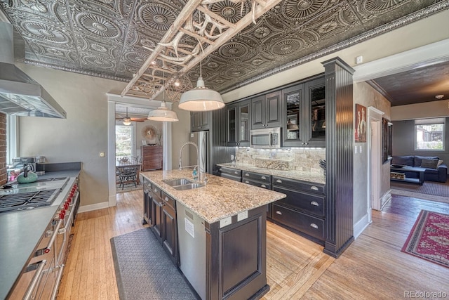 403 Scott St, Salida, CO 81201 - kitchen featuring a sink, stainless steel microwave, wall chimney range hood, cooktop, and an ornate ceiling