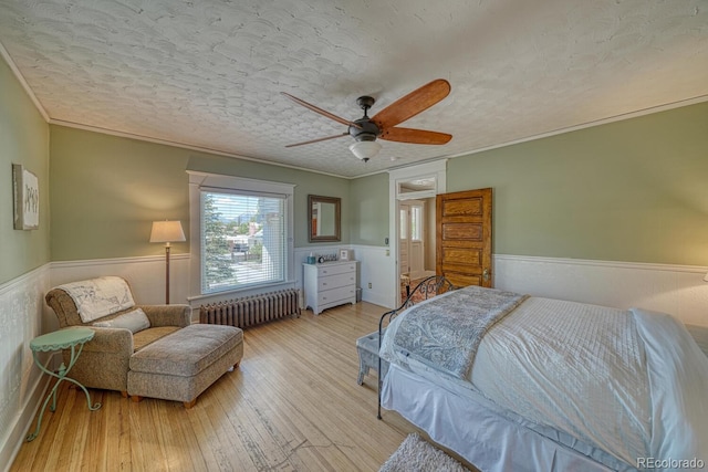 403 Scott St, Salida, CO 81201 - bedroom with radiator heating unit, wainscoting, wood-type flooring, crown molding, and ceiling fan