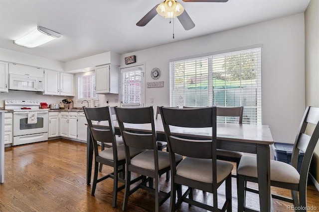 kitchen featuring white appliances, sink, dark hardwood / wood-style flooring, ceiling fan, and white cabinets