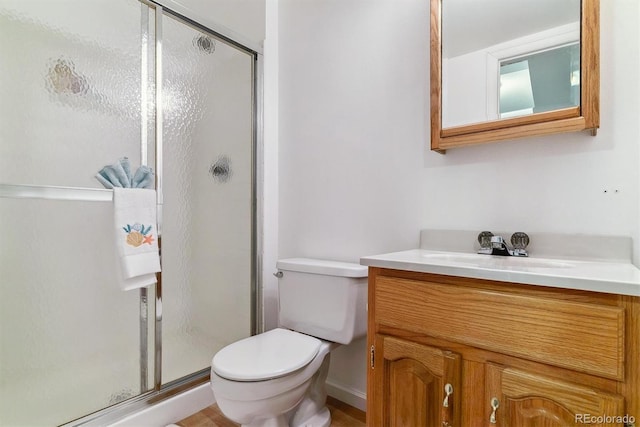 bathroom with vanity, a shower with shower door, and toilet