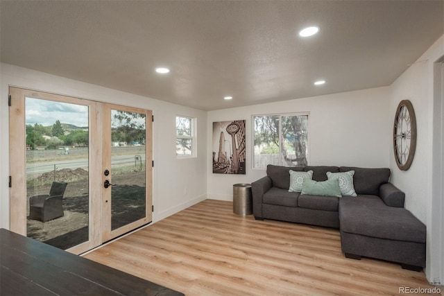 living room featuring hardwood / wood-style flooring, a textured ceiling, and french doors