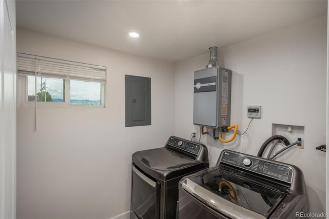 clothes washing area featuring electric panel, tankless water heater, and independent washer and dryer