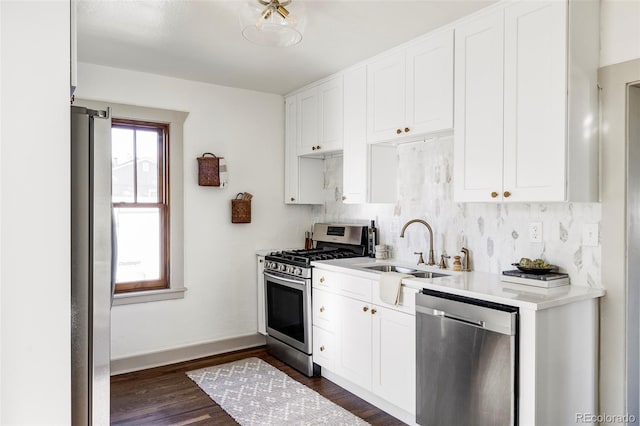 kitchen featuring white cabinets, dark hardwood / wood-style flooring, stainless steel appliances, decorative backsplash, and sink