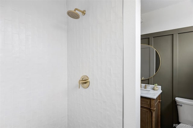 bathroom with toilet, vanity, and a shower