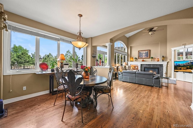 8518 High Rdg, Castle Pines, CO 80108 - dining area with a ceiling fan, ornate columns, wood finished floors, baseboards, and a glass covered fireplace