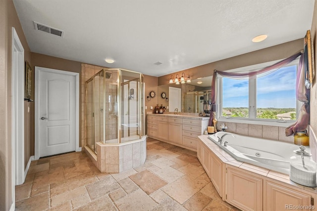 8518 High Rdg, Castle Pines, CO 80108 - bathroom with stone tile flooring, vanity, a shower stall, a whirlpool tub, and recessed lighting