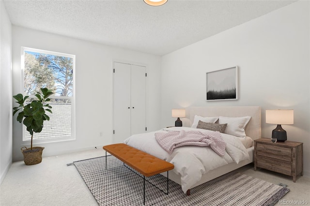 carpeted bedroom with a closet and a textured ceiling