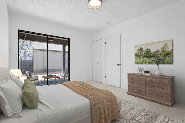 carpeted bedroom featuring access to exterior and a textured ceiling