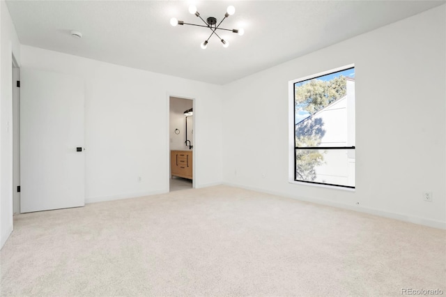 unfurnished bedroom with connected bathroom, light colored carpet, and a chandelier