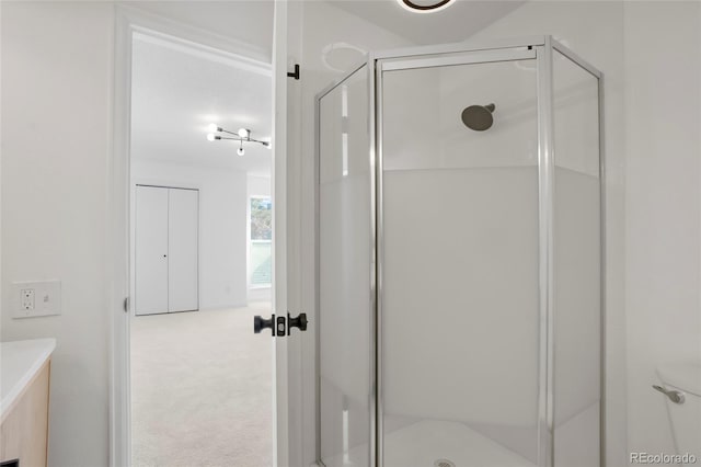 bathroom featuring vanity, a shower with shower door, and toilet