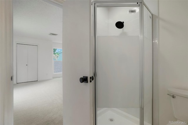 bathroom featuring toilet and an enclosed shower