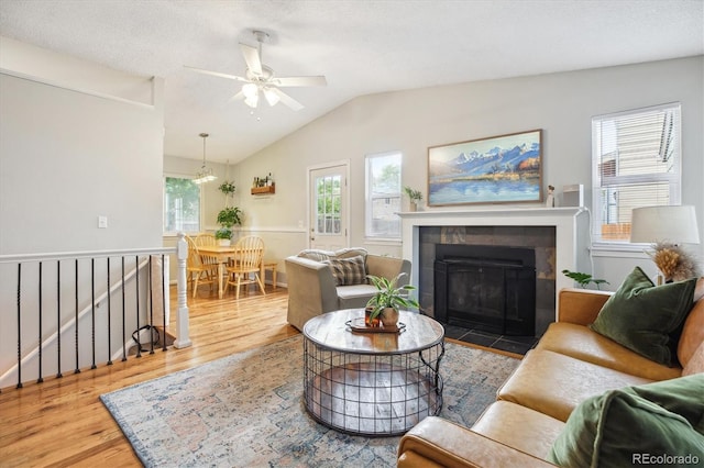 5007 S Richfield Cir, Aurora, CO 80015 - living area featuring wood finished floors, ceiling fan, vaulted ceiling, and a tile fireplace