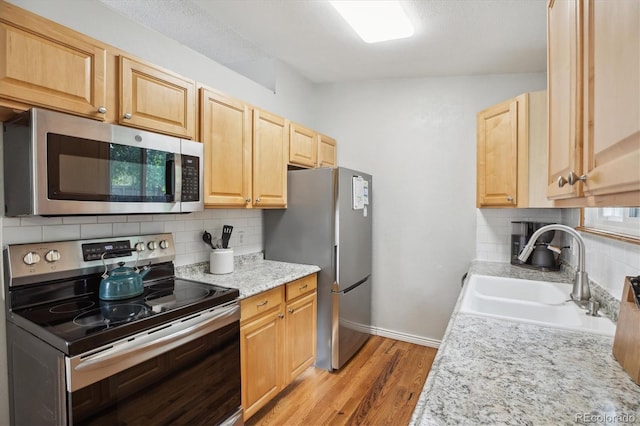 5007 S Richfield Cir, Aurora, CO 80015 - kitchen with stainless steel appliances, a sink, light countertops, light wood finished floors, and light brown cabinetry