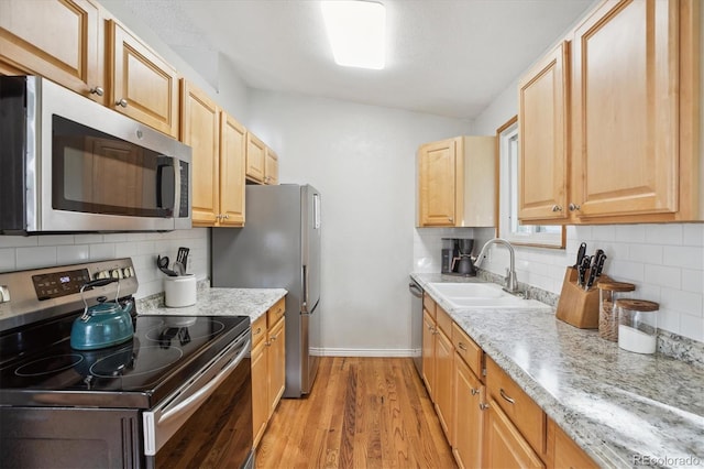 5007 S Richfield Cir, Aurora, CO 80015 - kitchen with appliances with stainless steel finishes, a sink, baseboards, light wood-type flooring, and backsplash
