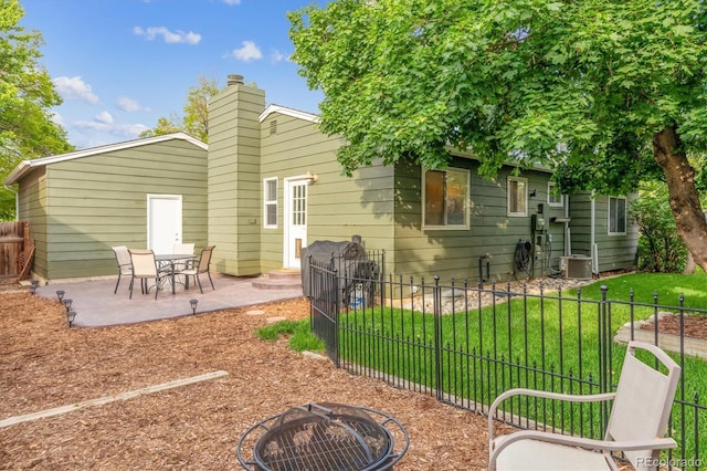 5007 S Richfield Cir, Aurora, CO 80015 - back of property with a fire pit, a patio area, a chimney, central AC unit, and entry steps