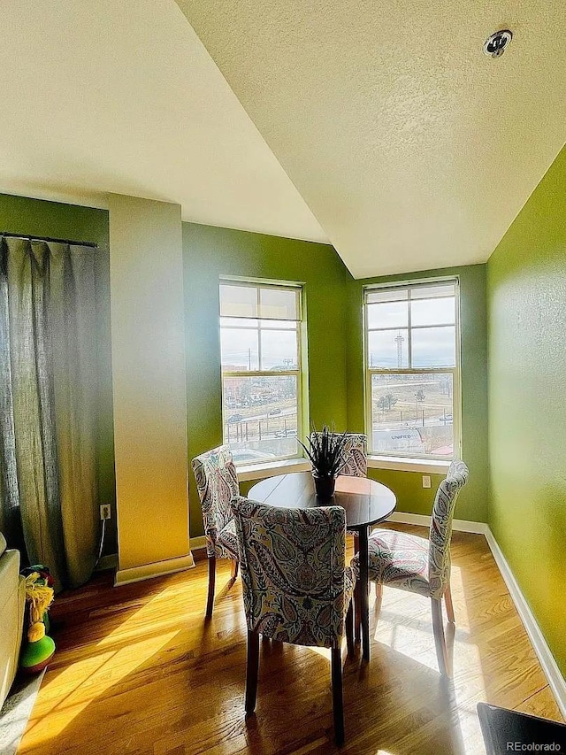 1441 Central St Unit 211, Denver, CO 80211 - dining area with wood finished floors, a textured ceiling, and baseboards