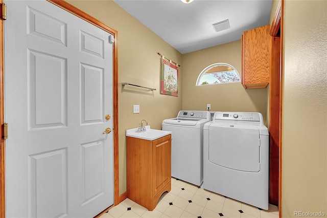 washroom with washer and dryer, a sink, cabinet space, and visible vents