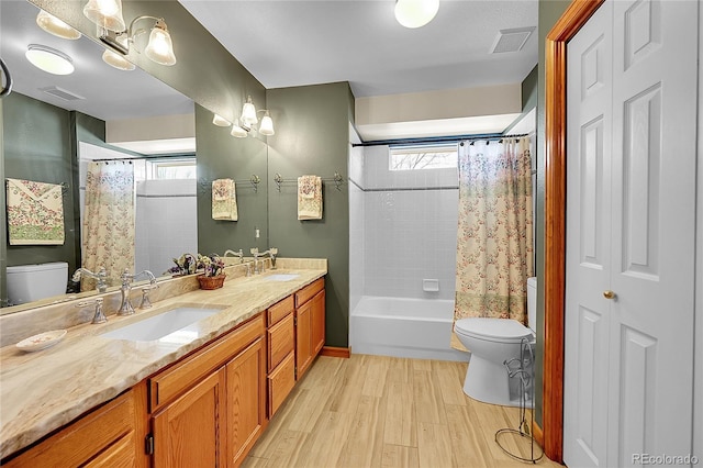 bathroom with a sink, visible vents, toilet, and wood finished floors