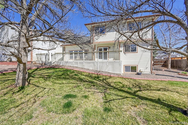 back of property featuring fence and a lawn