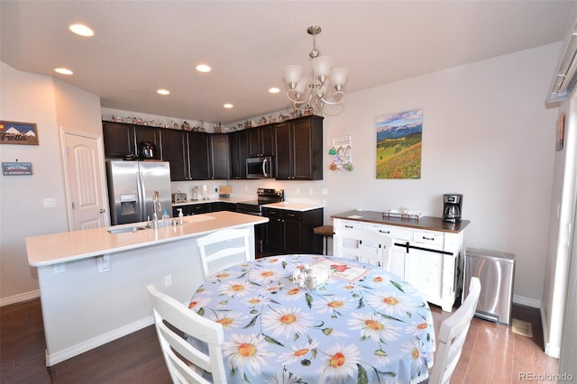 10511 Desert Bloom Way, Colorado Springs, CO 80925 - kitchen with appliances with stainless steel finishes, recessed lighting, light countertops, a center island with sink, and a chandelier