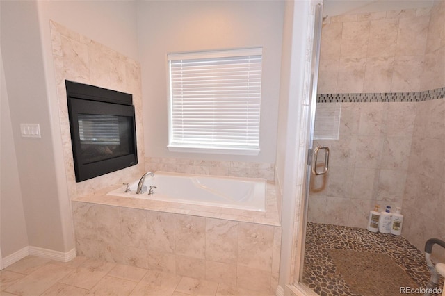 10511 Desert Bloom Way, Colorado Springs, CO 80925 - full bath with a stall shower, a bath, tile patterned flooring, and a glass covered fireplace