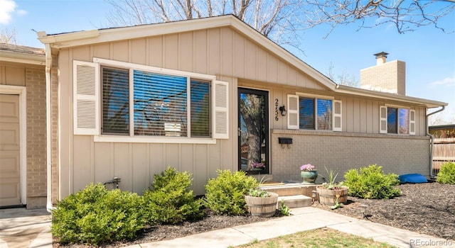 2756 E Euclid Ave, Centennial, CO 80121 - view of front facade featuring a chimney, brick siding, fence, and board and batten siding