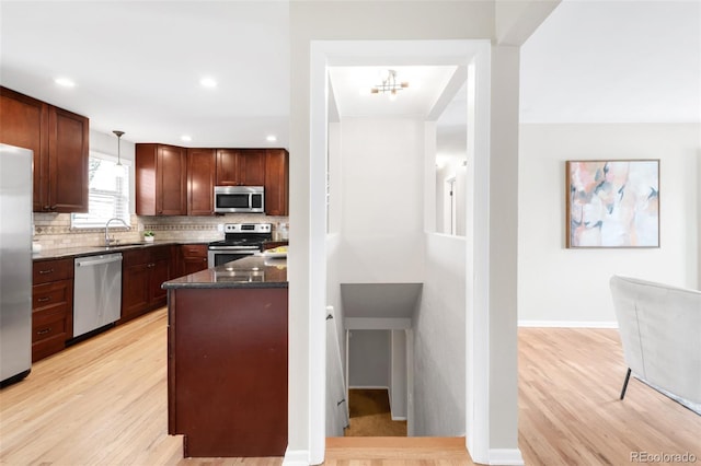 2756 E Euclid Ave, Centennial, CO 80121 - kitchen featuring stainless steel appliances, a sink, light wood-type flooring, tasteful backsplash, and dark stone counters