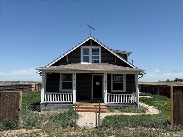 227 Milton St, Briggsdale, CO 80611 - bungalow featuring covered porch, a fenced front yard, roof with shingles, and a gate