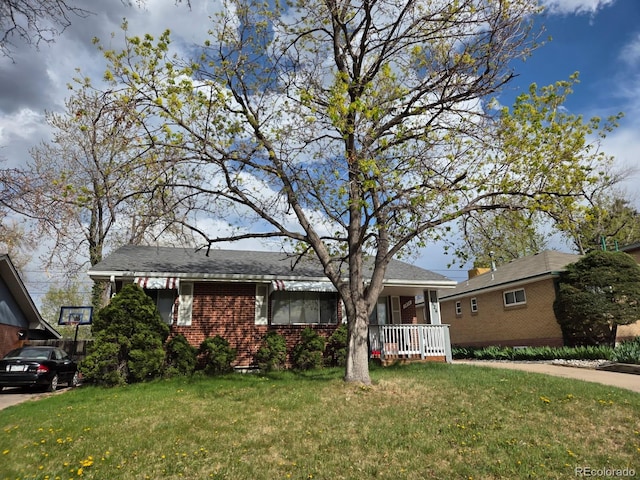 ranch-style house featuring brick siding, a front lawn, and covered porch