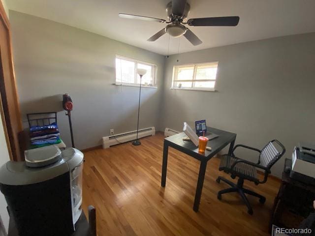 office area with light wood finished floors, ceiling fan, a baseboard heating unit, and baseboard heating