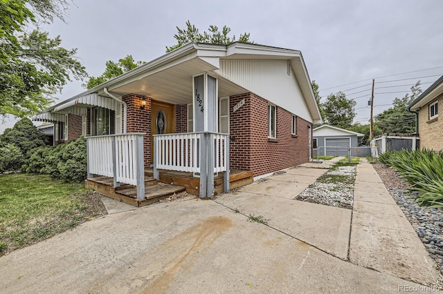 1824 S Columbine St, Denver, CO 80210 - view of front of house with driveway, covered porch, brick siding, and a detached garage